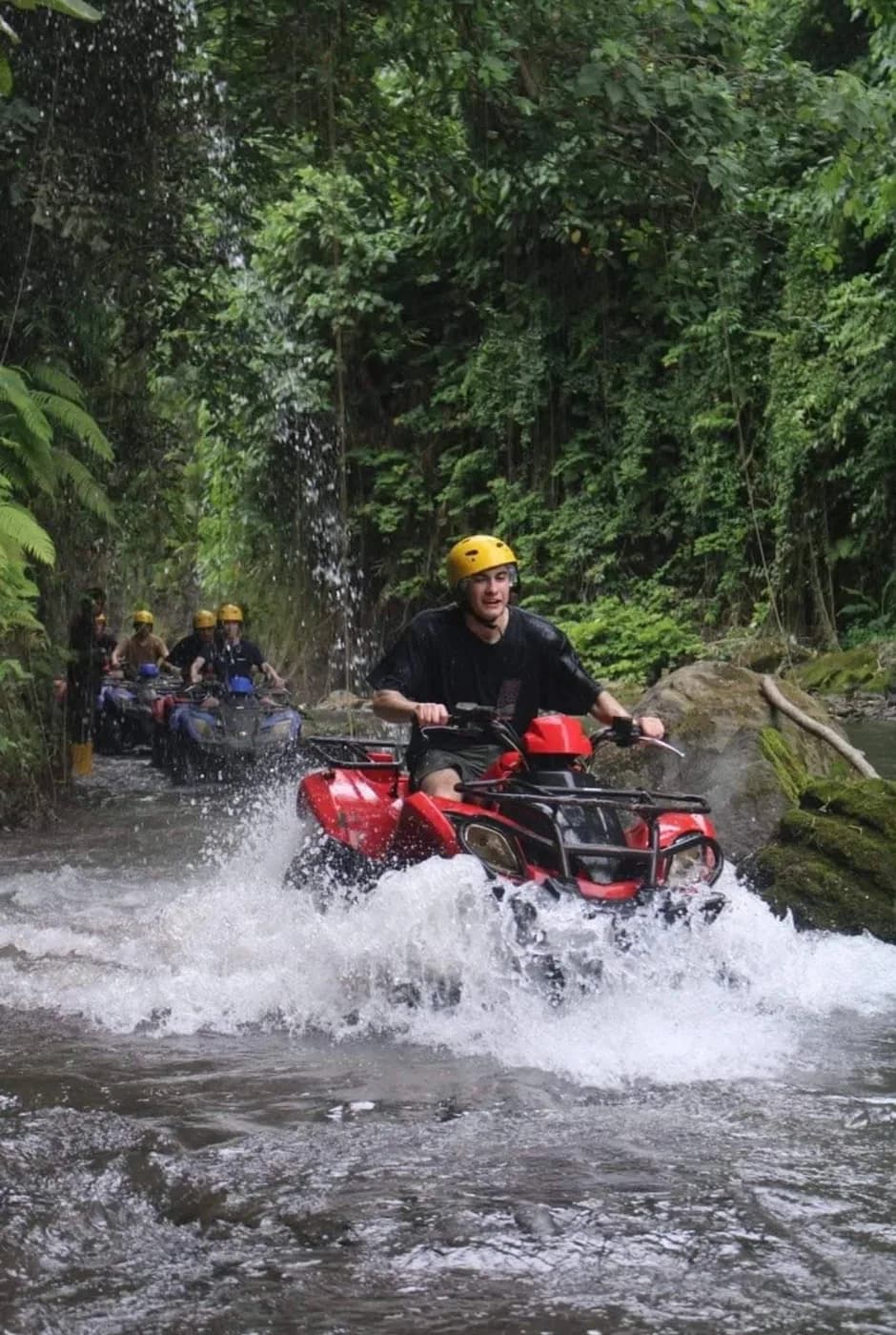 An ATV crossing a river on the jungle trail